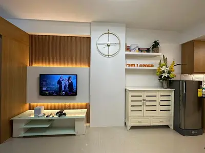 a kitchen with a refrigerator and a tv on the wall at Shell Residences, Pasay near NAIA MOA SMX PICC in Manila