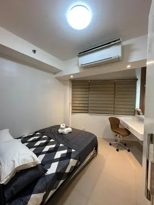 a bedroom with a bed and a desk and a bed sidx sidx sidx at Shell Residences, Pasay near NAIA MOA SMX PICC in Manila