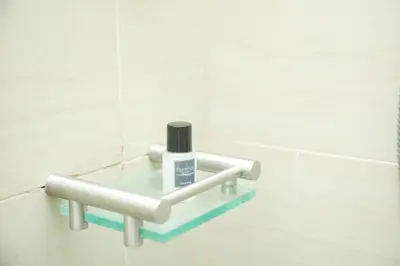 a bottle of soap on a glass shelf in a bathroom at Shore2 Luxurious & Homely Suite near MOA in Manila