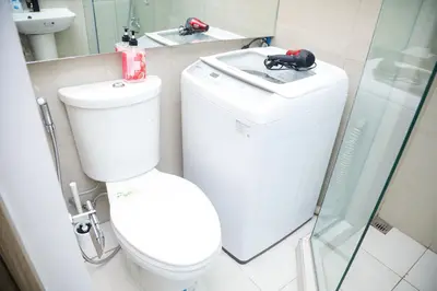 a bathroom with a toilet and a sink at Shore2 Luxurious & Homely Suite near MOA in Manila