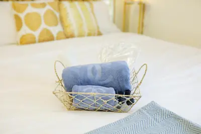 a basket of towels sitting on a bed at Shore2 Luxurious & Homely Suite near MOA in Manila