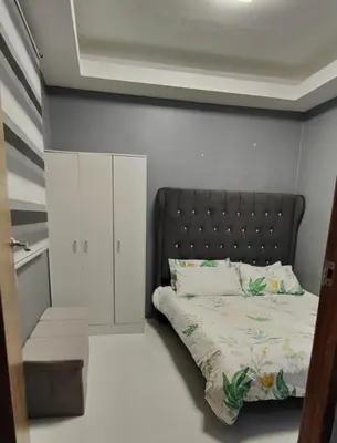 a bedroom with a bed with a black headboard at Sky Haven Staycation in Rizal