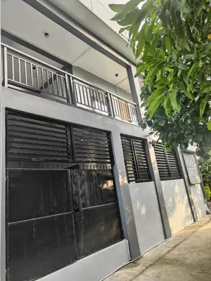 a white building with black doors and windows at Sky Haven Staycation in Rizal