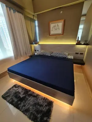 a bedroom with a large blue bed in a room at Beautiful Condo in BGC Taguig - McKinley in Manila