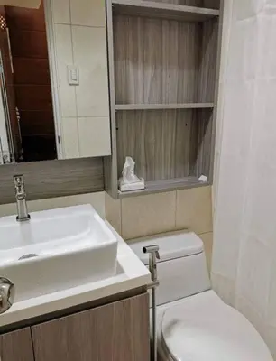 a bathroom with a sink and a toilet and a mirror at Beautiful Condo in BGC Taguig - McKinley in Manila
