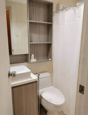 a small bathroom with a toilet and a sink at Beautiful Condo in BGC Taguig - McKinley in Manila