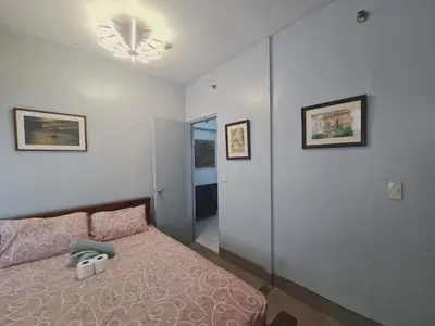 a bedroom with a bed and a ceiling fan at 1 Bedroom Condo In Little Baguio Terraces, San Juan City in Manila