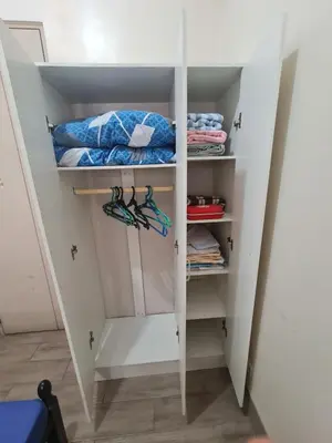 a walk in closet with white doors and hangers at 1 Bedroom Condo In Little Baguio Terraces, San Juan City in Manila