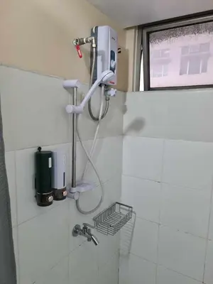 a shower in a white tiled bathroom at 1 Bedroom Condo In Little Baguio Terraces, San Juan City in Manila