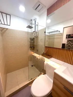 a bathroom with a toilet and a glass shower at Stanford Suites 3 in Silang