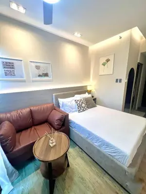 a bedroom with a bed and a couch and a table at Stanford Suites 3 in Silang