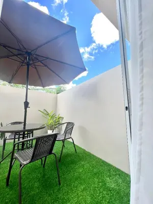 a patio with a table and chairs and an umbrella at Stanford Suites 3 in Silang