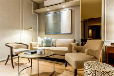 a living room with a couch and chairs and a table at Brittany Hotel Villar City in Cavite