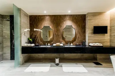 a bathroom with two sinks and two mirrors at Brittany Hotel Villar City in Cavite