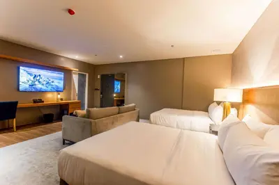 a hotel room with two beds and a flat screen tv at Brittany Hotel Villar City in Cavite