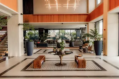a lobby of a hotel with a table and benches at Brittany Hotel Villar City in Cavite