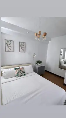 a white bedroom with a large white bed and lights at 2-Bed Apartment in Near Airport Paranaque in Manila