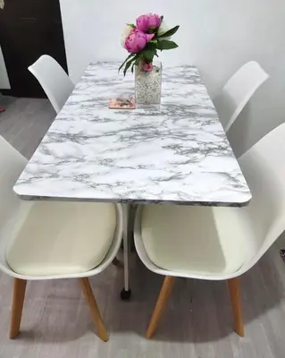 a marble table with two chairs and a vase of flowers at 2-Bed Apartment in Near Airport Paranaque in Manila