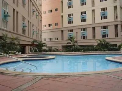 a large swimming pool in front of a building at Renovated 2br 2tb Wifi/Netflix very near Mall QC in Manila