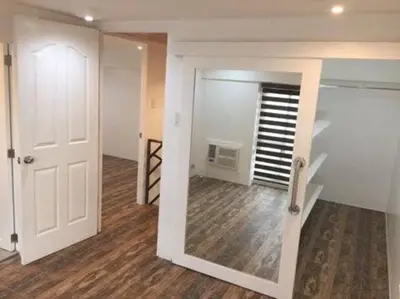 an empty room with a staircase and a white door at Renovated 2br 2tb Wifi/Netflix very near Mall QC in Manila