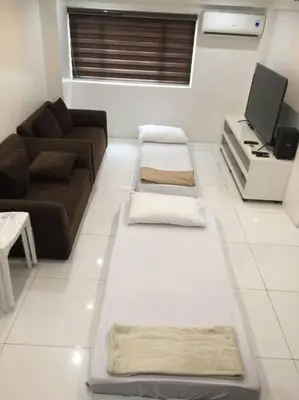 a living room with a couch and a tv at Renovated 2br 2tb Wifi/Netflix very near Mall QC in Manila