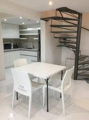 a white table and white chairs in a kitchen at Renovated 2br 2tb Wifi/Netflix very near Mall QC in Manila