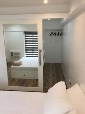 a bedroom with a bed and a large mirror at Renovated 2br 2tb Wifi/Netflix very near Mall QC in Manila