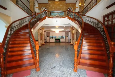 an ornate wooden staircase in a house at Villa Jhoana Resort in Angono