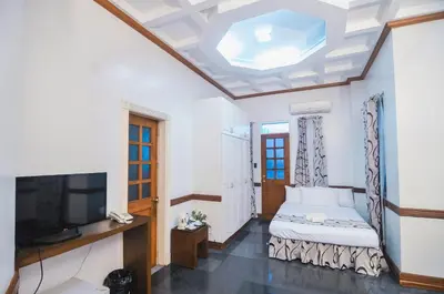 a room with a bed and a flat screen tv at Villa Jhoana Resort in Angono