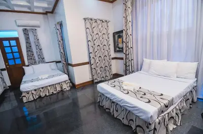 a bedroom with two beds and a window at Villa Jhoana Resort in Angono