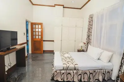 a hotel room with a bed and a television at Villa Jhoana Resort in Angono