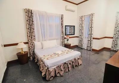 a bedroom with a bed in a room with windows at Villa Jhoana Resort in Angono