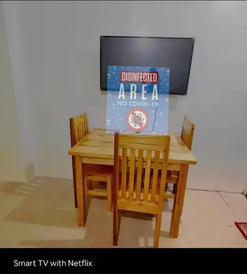 a wooden table and chairs with a sign on it at Condo Premium Near NAIA T123 in Manila