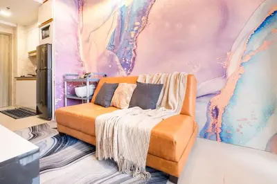 a room with a couch and a colorful wall at Minju Staycation at Fame Residences Free Netflix & Wifi in Manila