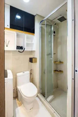 a bathroom with a toilet and a glass shower at Minju Staycation at Fame Residences Free Netflix & Wifi in Manila