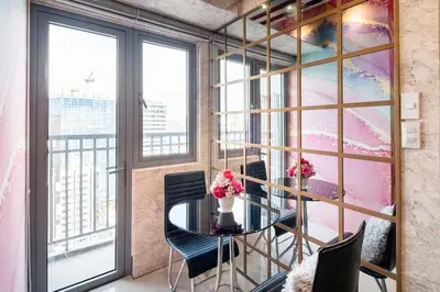 a dining room with a table and chairs and windows at Minju Staycation at Fame Residences Free Netflix & Wifi in Manila