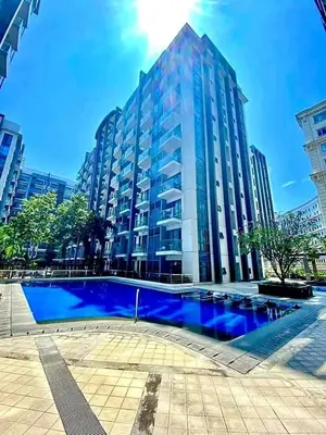 a large blue pool in front of a large building at Airport staycation @MRMCONDOTEL in Manila