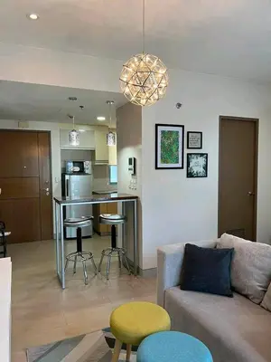 a living room with a couch and a kitchen at Airport staycation @MRMCONDOTEL in Manila