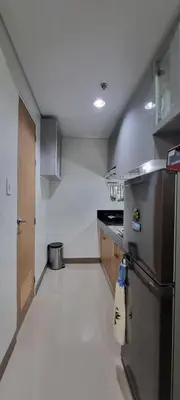 a kitchen with a stainless steel refrigerator and cabinets at 2BR Irish Luck Holiday Apartment in Manila