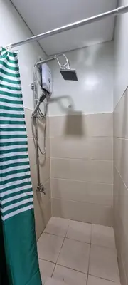a bathroom with a shower with a green towel at 2BR Irish Luck Holiday Apartment in Manila