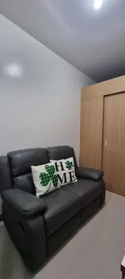 a black leather couch in a living room at 2BR Irish Luck Holiday Apartment in Manila