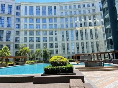 a large building with a large pool in front of it at studio condo building 81 newport boulevard in Manila