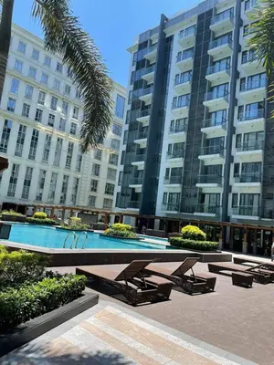 a swimming pool in front of a large building at studio condo building 81 newport boulevard in Manila