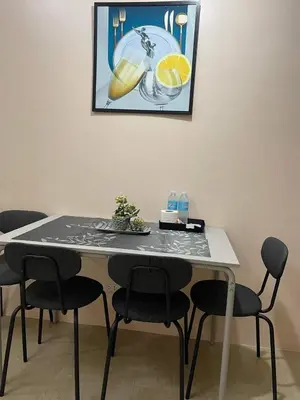 a dining room table with chairs and a picture on the wall at studio condo building 81 newport boulevard in Manila