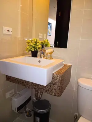 a bathroom with a white sink and a toilet at studio condo building 81 newport boulevard in Manila