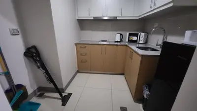 a small kitchen with a sink and a microwave at BGC Uptown Mall Suite in Manila