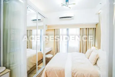 a bedroom with a bed and a mirror at Air Residences Makati with Sunset View in Manila