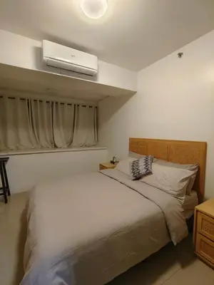 a bedroom with a bed with a air conditioner at METRO STAYCATION PASAY MALL OF ASIA in Manila