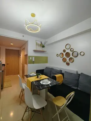 a living room with a couch and a table and chairs at METRO STAYCATION PASAY MALL OF ASIA in Manila