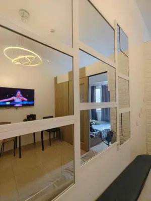 a living room with a large window and a tv at METRO STAYCATION PASAY MALL OF ASIA in Manila